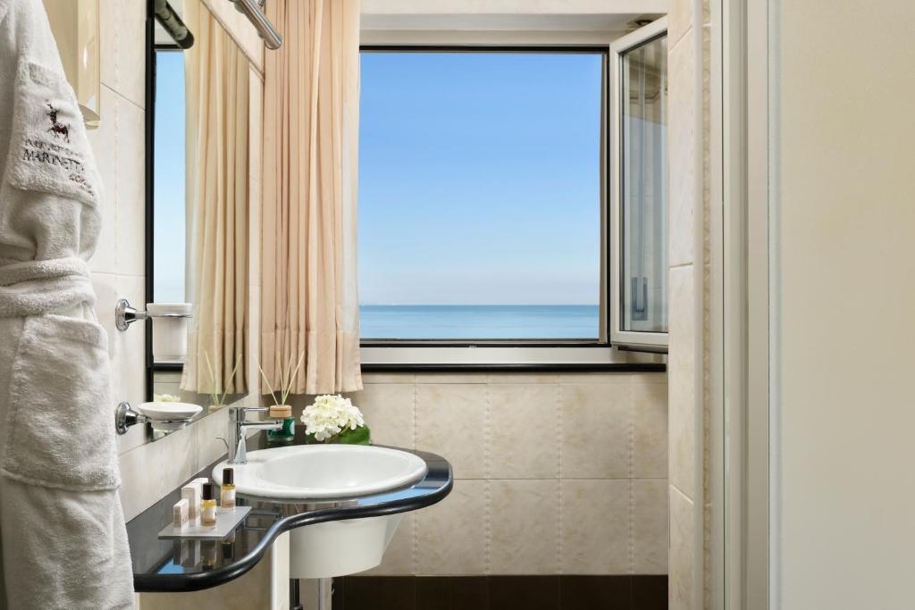 une salle de bain avec un lavabo et une fenêtre dans l'établissement Park Hotel Marinetta - Beach & Spa, à Marina di Bibbona