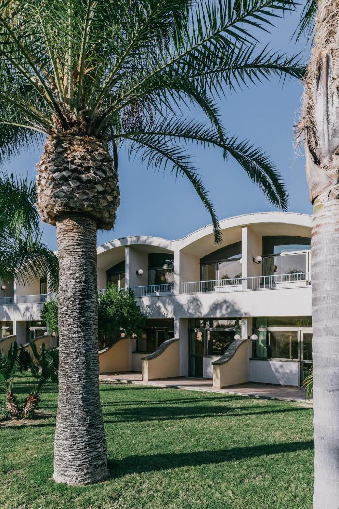 un palmier devant un bâtiment dans l'établissement MClub Alicudi, à Sciacca