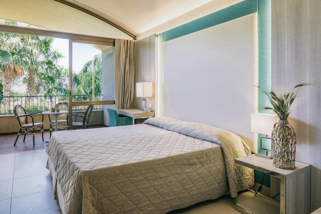 une chambre avec un lit et un balcon dans l'établissement MClub Alicudi, à Sciacca