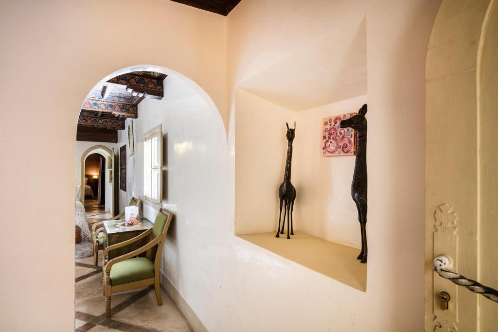 - un couloir avec une chambre dotée d'une girafe sur le mur dans l'établissement Riad Le Rihani, à Marrakech
