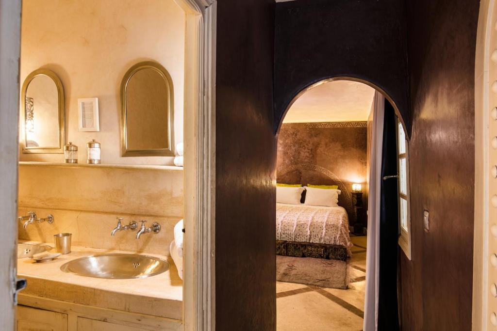 La salle de bains est pourvue d'un lavabo et d'un lit dans la chambre. dans l'établissement Riad Le Rihani, à Marrakech
