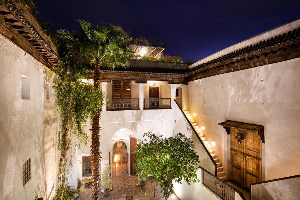 une cour intérieure d'un immeuble avec un palmier dans l'établissement Riad Le Rihani, à Marrakech