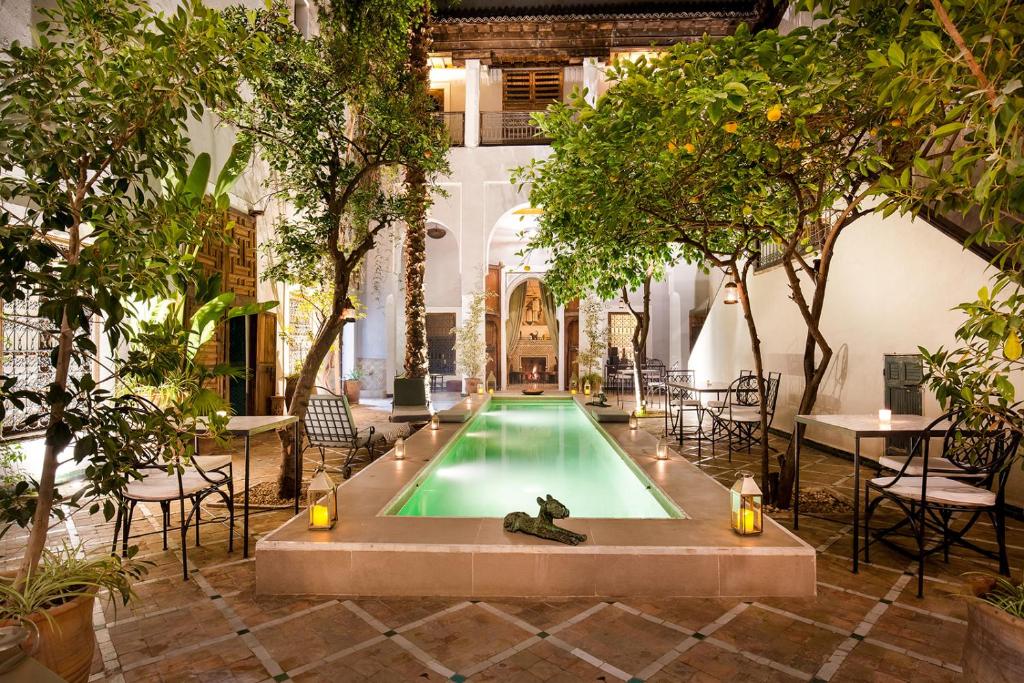 une piscine au milieu d'une cour arborée dans l'établissement Riad Le Rihani, à Marrakech
