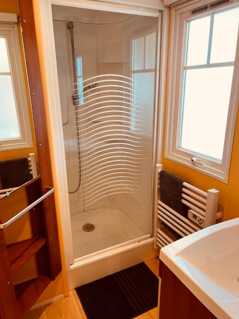 une salle de bain avec une douche avec une porte vitrée dans l'établissement Joli Mobil-Home de Vacances, Ideal pour les familles, à Rocbaron