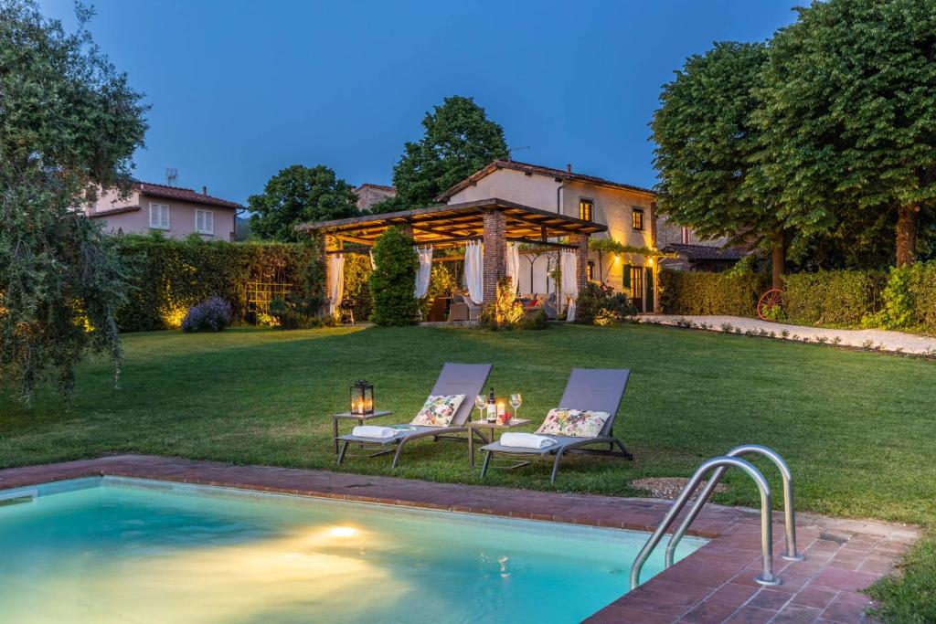 une cour arrière avec une piscine et une maison dans l'établissement Pennecchio, à Lucques