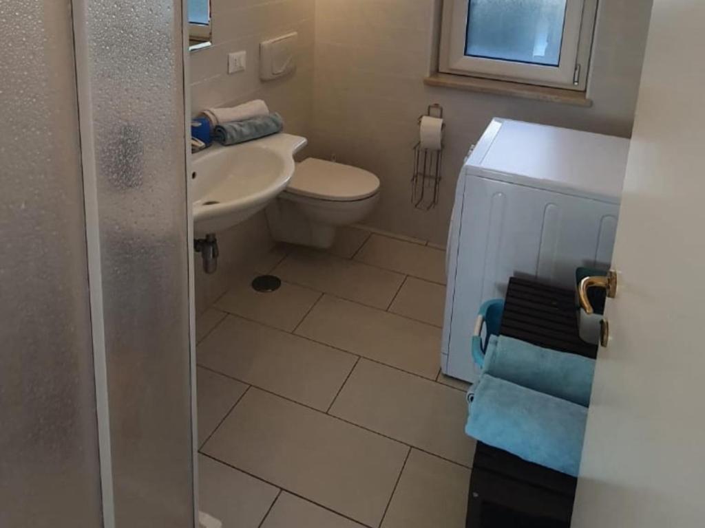 une salle de bain avec des toilettes blanches et un lavabo dans l'établissement Villa sunset, à Zambrone