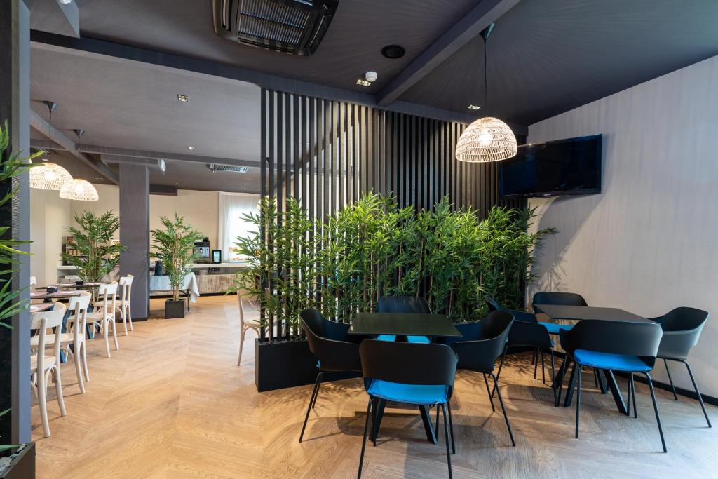 un restaurant avec des tables, des chaises et des plantes en pot dans l'établissement B&B Isabella, à Milano Marittima