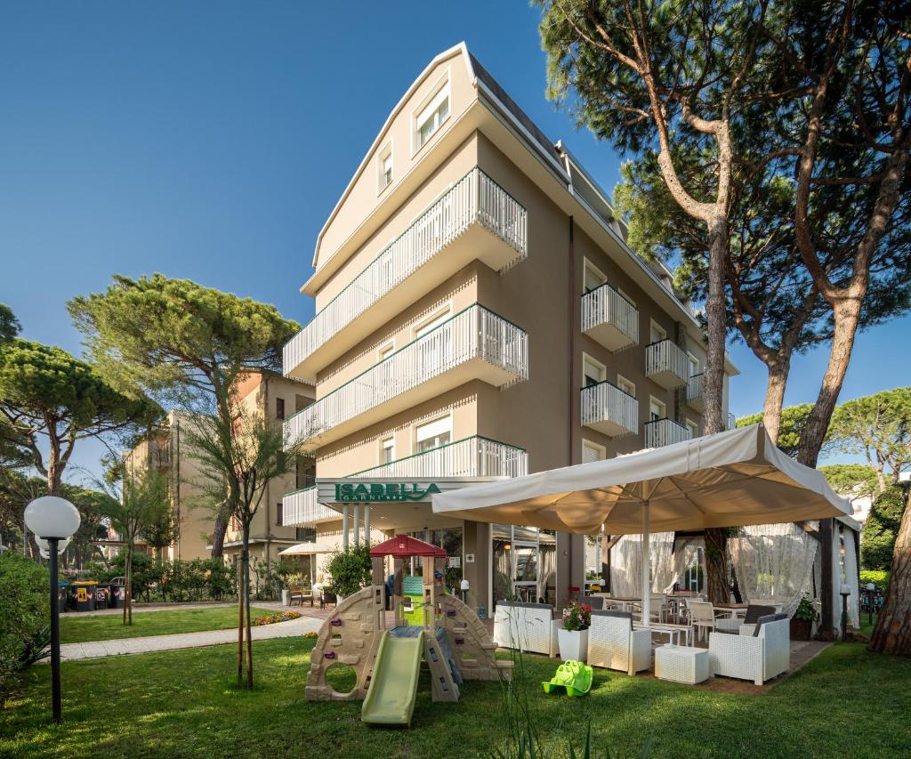 un bâtiment avec des tables et des parasols devant lui dans l'établissement B&B Isabella, à Milano Marittima