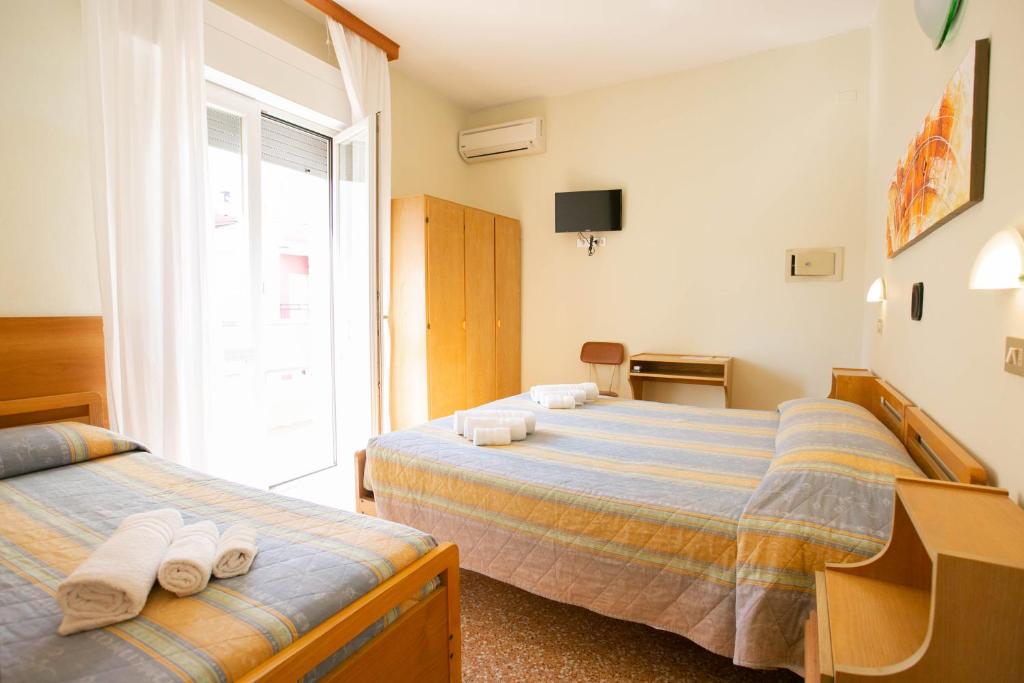 une chambre avec deux lits et une fenêtre dans l'établissement Hotel Ischia, à Rimini