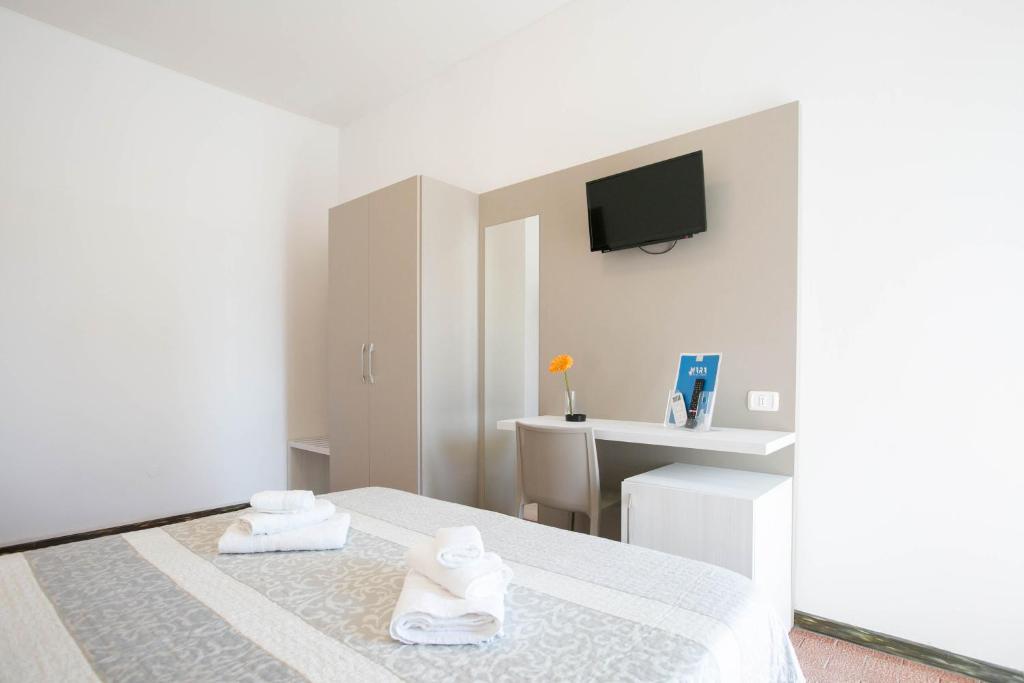 une chambre blanche avec un lit avec deux serviettes dans l'établissement Hotel Mara, à Rimini