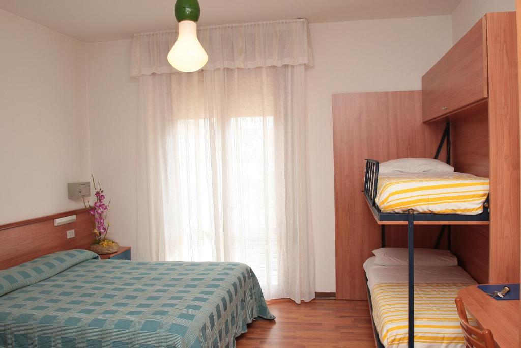 une chambre avec deux lits superposés et une fenêtre dans l'établissement Hotel Midi, à Lido di Jesolo