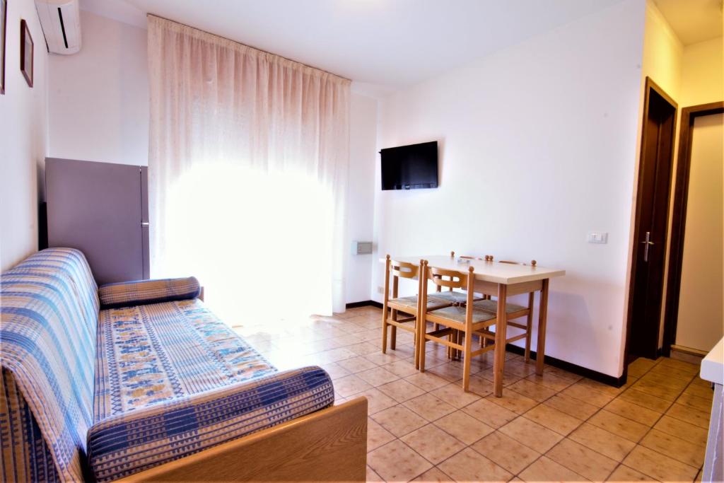 un salon avec un lit et une table de salle à manger dans l'établissement Residence Columbia, à Bibione