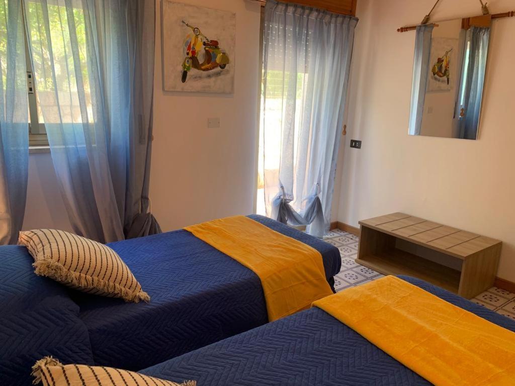 - une chambre dotée de 2 lits avec des draps bleus et jaunes dans l'établissement Villa Cycas Costamante, à Castellammare del Golfo 42 autres photos