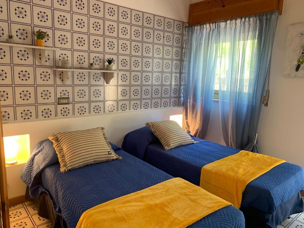 une chambre avec deux lits et une fenêtre dans l'établissement Villa Cycas Costamante, à Castellammare del Golfo