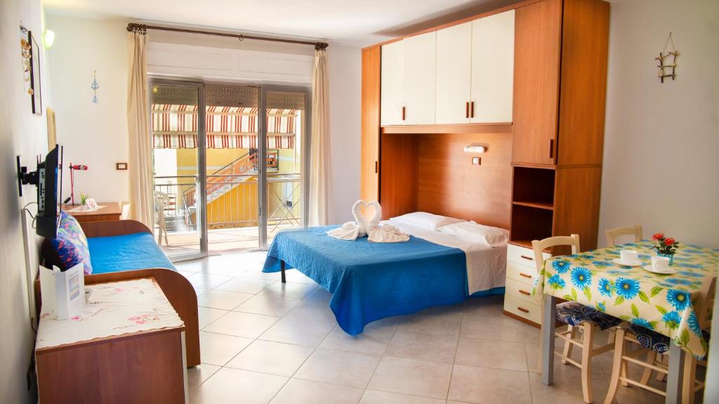 une chambre avec un lit et une table et une pièce dans l'établissement Residence Le Rose, à Marina di Bibbona