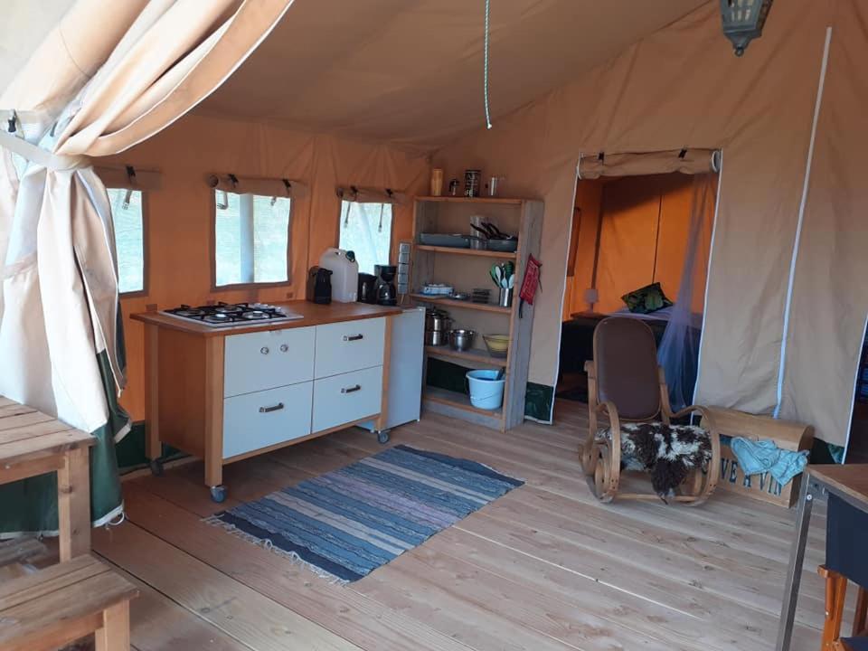 une tente avec une cuisine et une cuisinière dans une pièce dans l'établissement Luxe safarilodgetent met boxspring bedden, à Montcléra