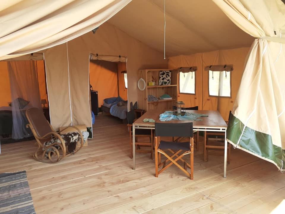 une tente avec une table et des chaises dans une chambre dans l'établissement Luxe safarilodgetent met boxspring bedden, à Montcléra