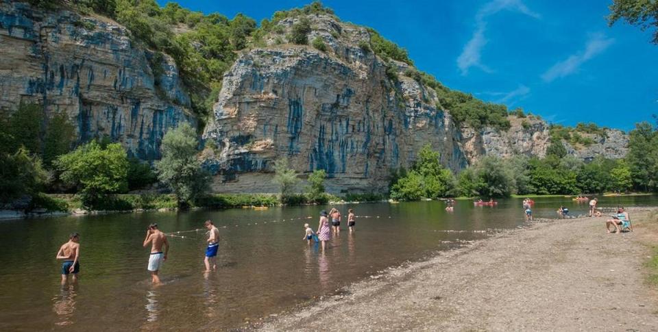 Un groupe de personnes dans l'eau d'une rivière dans l'établissement Luxe safarilodgetent met boxspring bedden, à Montcléra