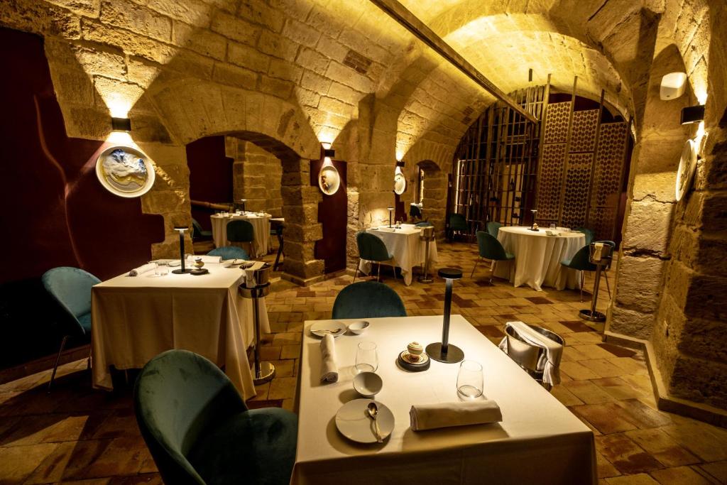 un restaurant avec des tables et des chaises dans une salle en pierre dans l'établissement Hotel Borgo di Ciàula, à Santa Flavia