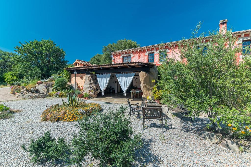 un bâtiment avec une table et des chaises dans une cour dans l'établissement Stazzu La Piredda, à Arzachena