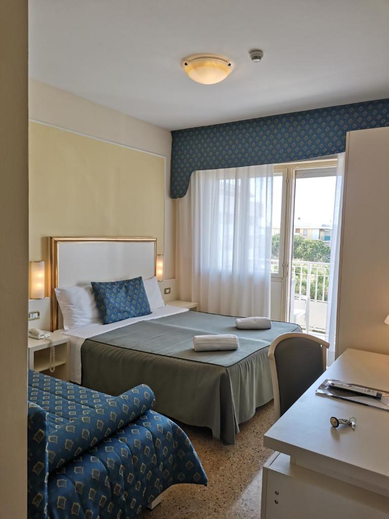 une chambre d'hôtel avec un lit et un canapé dans l'établissement Hotel Astoria, à Bibione