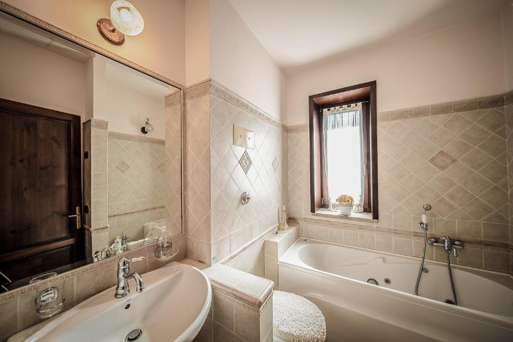 une salle de bain blanche avec une baignoire et un lavabo dans l'établissement Villa Lara, à Tortorici
