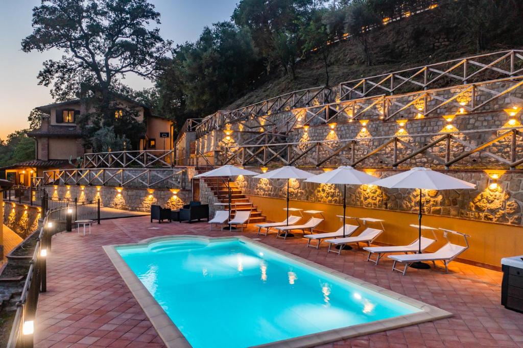 - une piscine avec des tables et des chaises à côté d'un bâtiment dans l'établissement Villa Lara, à Tortorici