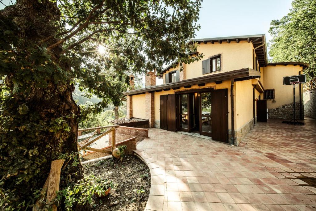 une maison avec un arbre devant dans l'établissement Villa Lara, à Tortorici