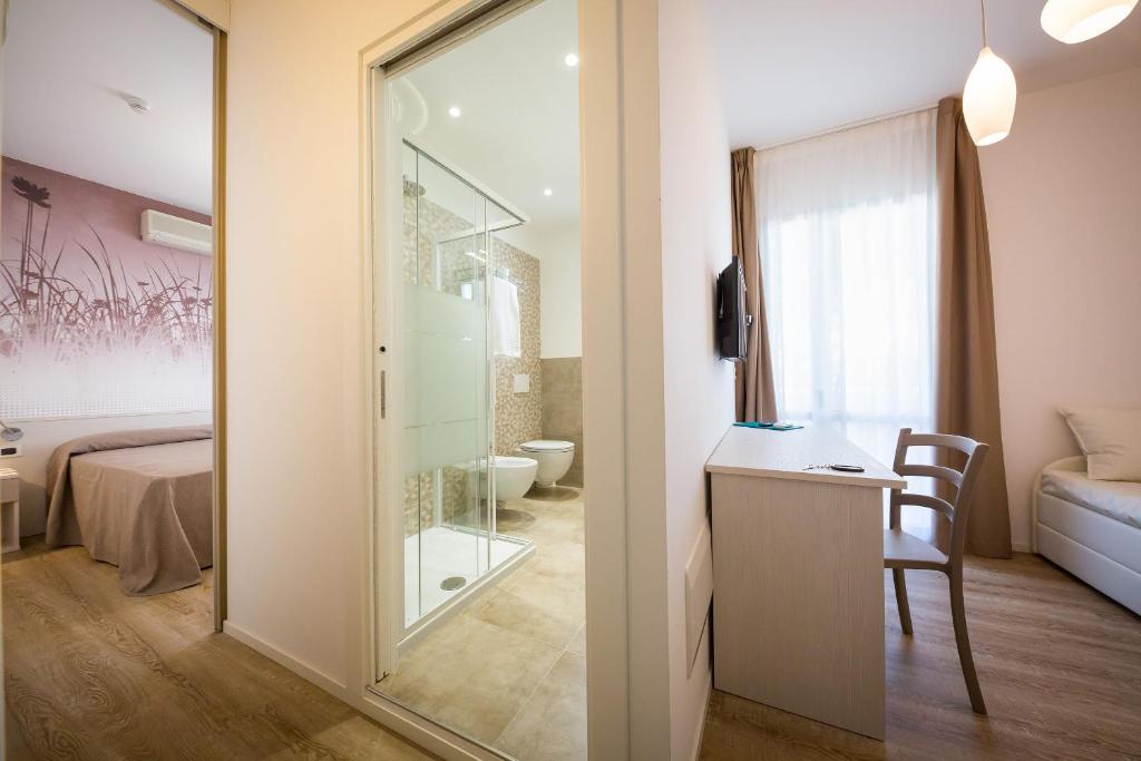 une chambre avec une porte en verre menant à une chambre dans l'établissement Hotel Villa Maria, à Caorle
