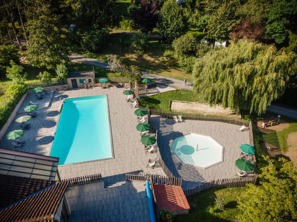 une vue aérienne d'une piscine avec chaises et parasols dans l'établissement Huttopia Sarlat, à Sarlat-la-Canéda