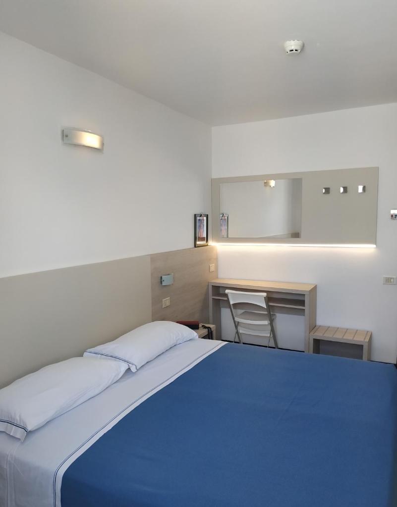 - une chambre avec un grand lit bleu et un lavabo dans l'établissement Residence Sangiorgi, à Cattolica