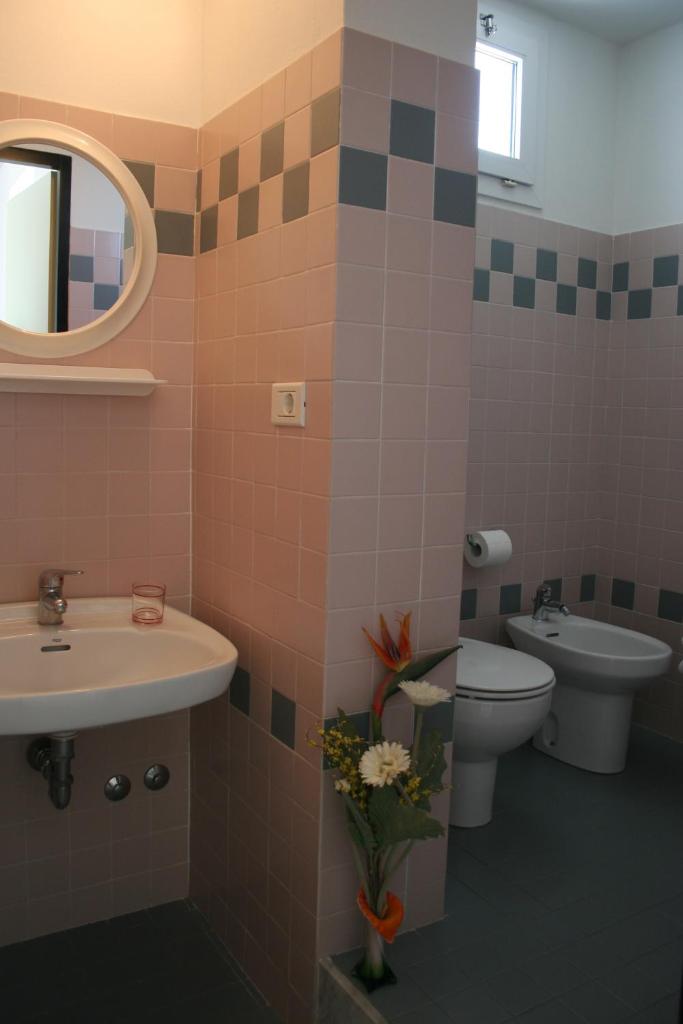 une salle de bain avec un lavabo, des toilettes et un miroir dans l'établissement Residence Sangiorgi, à Cattolica 23 autres photos
