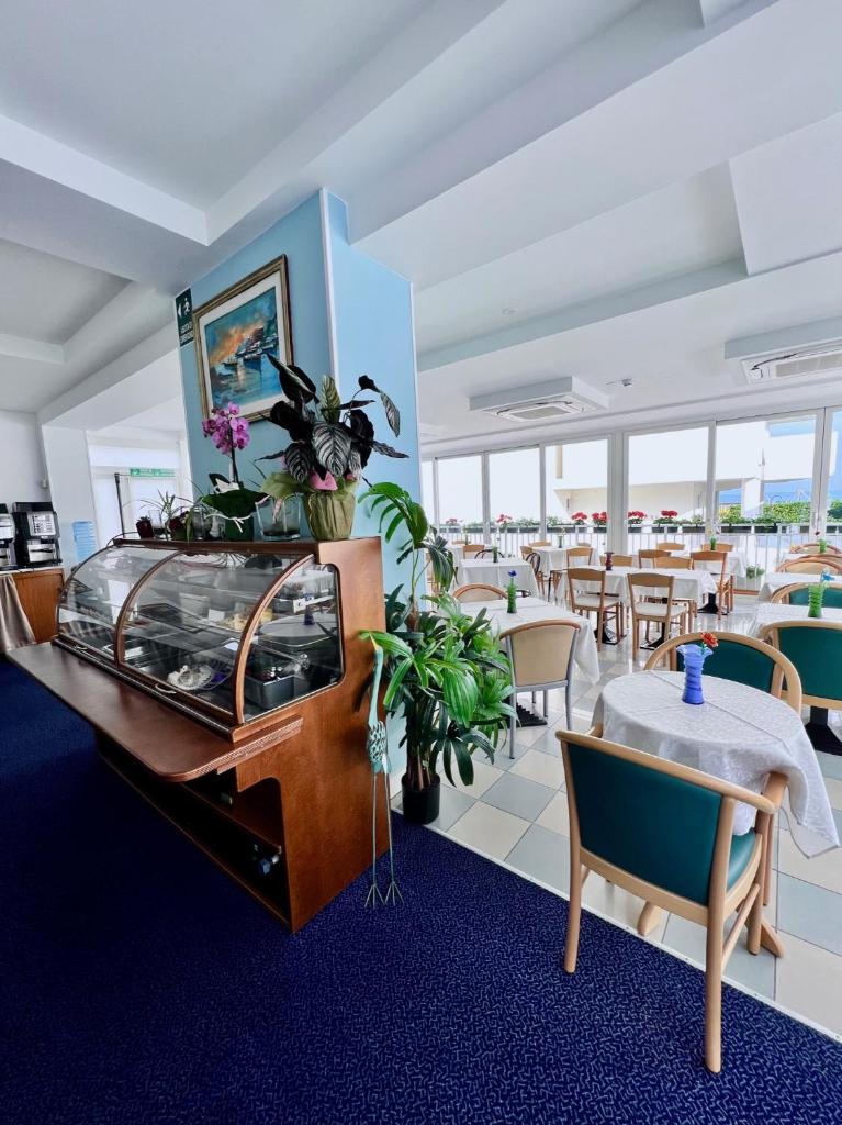un restaurant avec des tables, des chaises et un piano dans l'établissement Hotel Terramare, à Lido di Jesolo