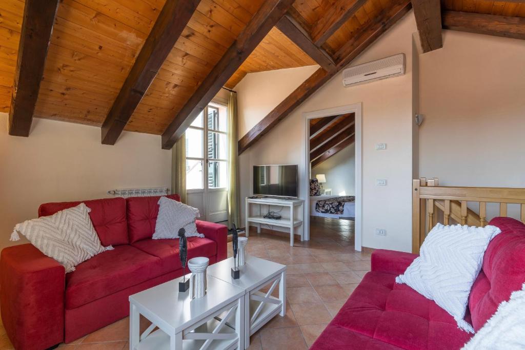 un salon avec deux canapés rouges et une table dans l'établissement Baba Residences, à Alassio