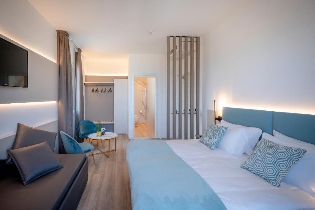 une chambre avec un grand lit et une table dans l'établissement Hotel Delfino, à Caorle 61 autres photos