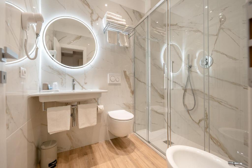 une salle de bain avec une douche, des toilettes et un lavabo dans l'établissement Hotel Delfino, à Caorle
