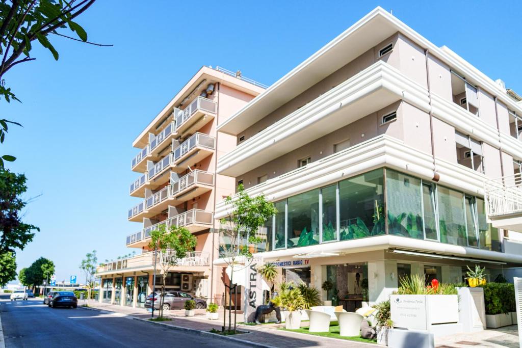 un grand bâtiment avec des fenêtres en verre sur une rue dans l'établissement Design Hotel Astra B&B, à Misano Adriatico