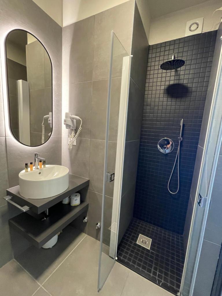 une salle de bain avec un lavabo et une douche avec un miroir dans l'établissement Hotel Iris Jesolo, à Lido di Jesolo 150 autres photos
