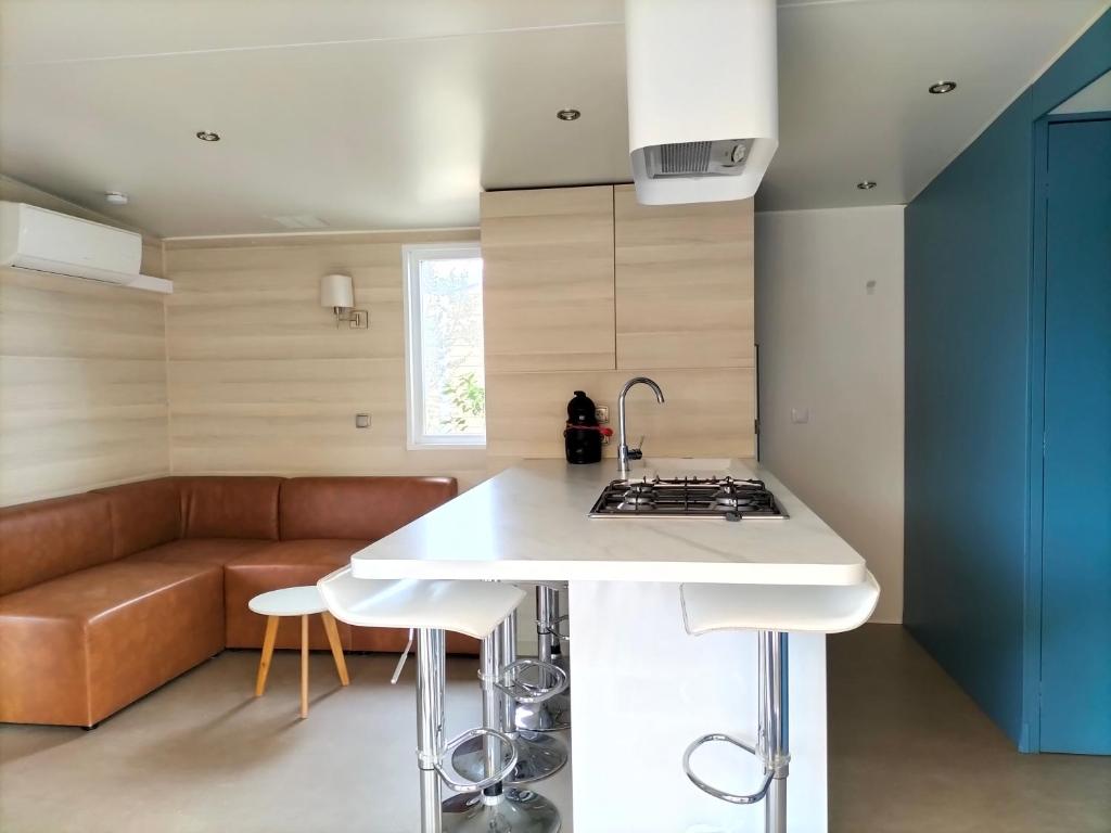 - une cuisine avec une cuisinière et un canapé dans la chambre dans l'établissement Camping, au Muy