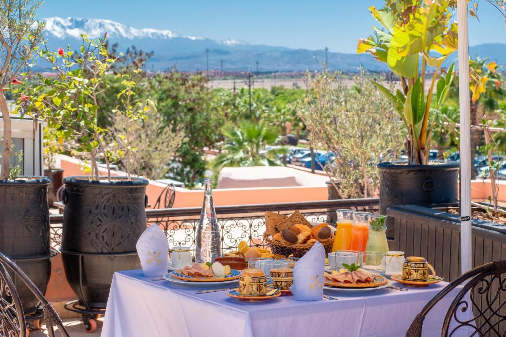 une table avec des assiettes de nourriture sur un balcon dans l'établissement Riad la clé d'or & spa, à Marrakech