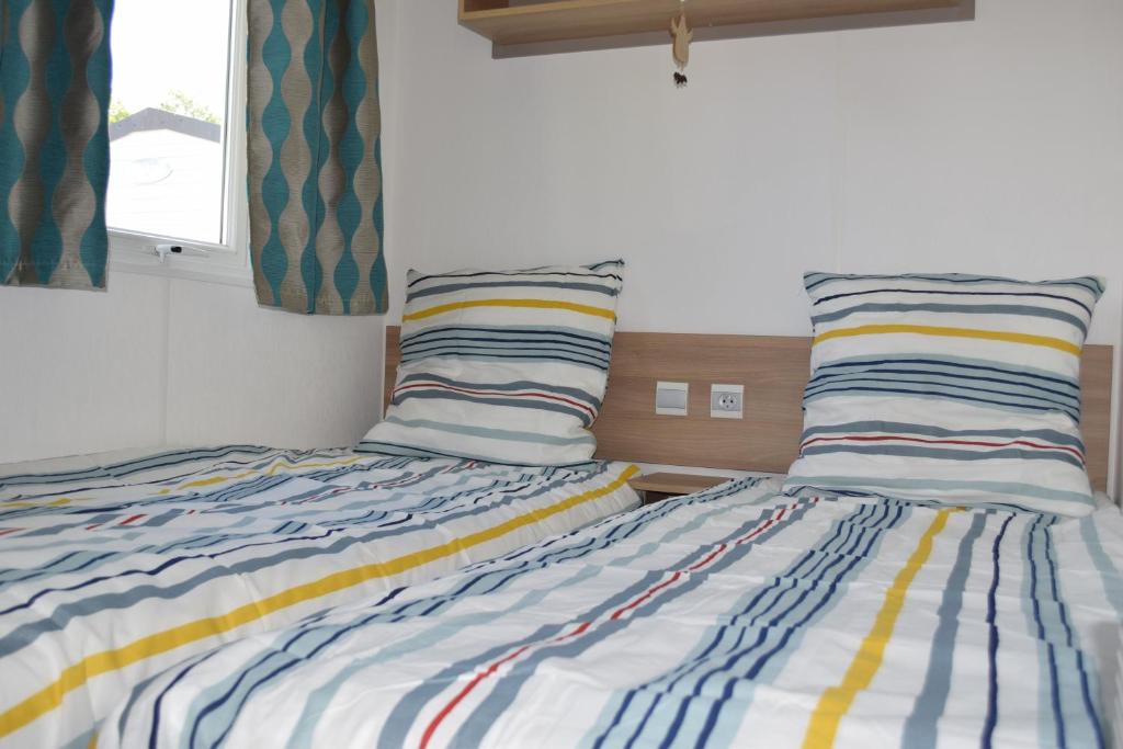 deux lits côte à côte dans une chambre dans l'établissement Mobil Home tout confort 6 personnes avec wifi, à Onzain