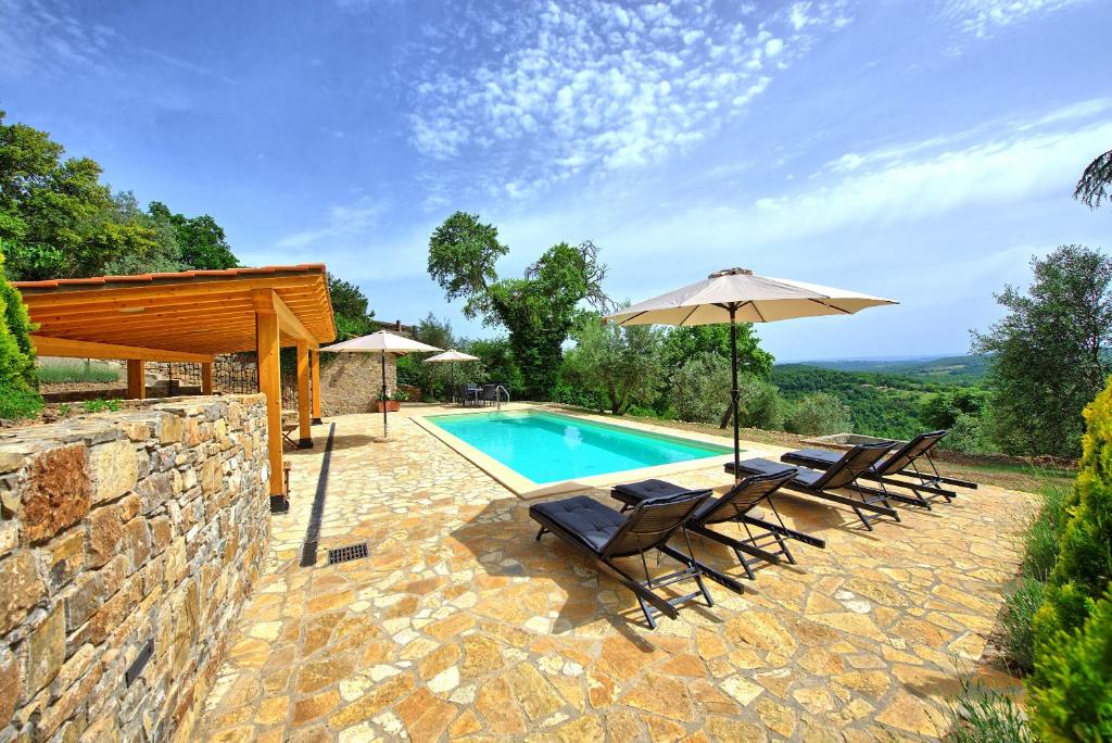 une piscine avec des chaises et un parasol dans l'établissement Villa Collina by PosarelliVillas, à Montegiove