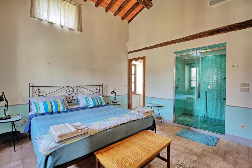 une chambre avec un lit et une douche en verre dans l'établissement Villa Collina by PosarelliVillas, à Montegiove 32 autres photos