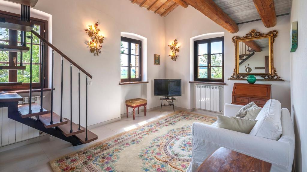 un salon avec un canapé blanc et une télévision dans l'établissement CASA MELOGRANO 11&2, Emma Villas, à Montefelcino