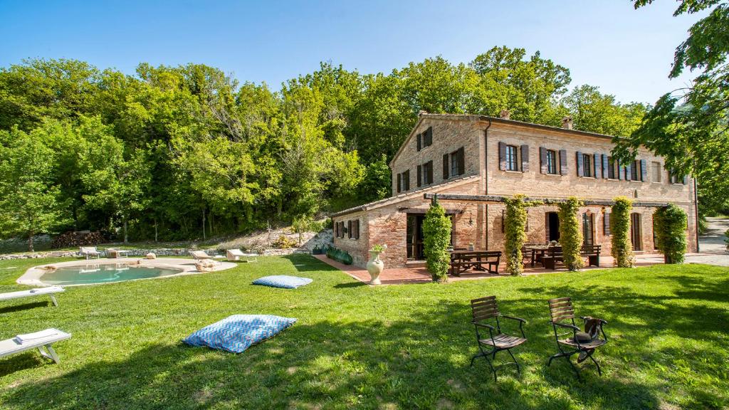 une vieille maison en pierre dans une cour avec une piscine dans l'établissement CASA MELOGRANO 11&2, Emma Villas, à Montefelcino