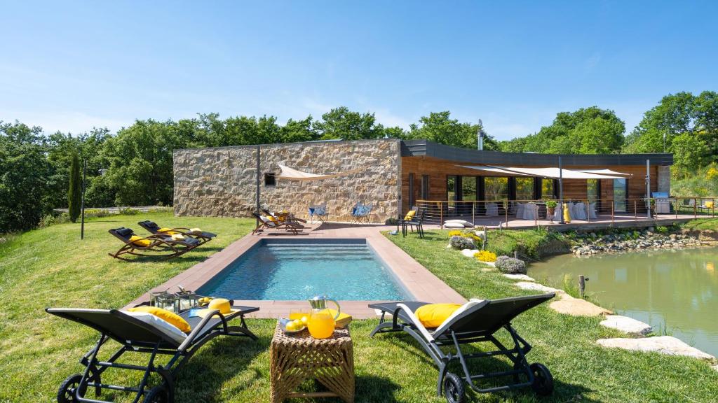 une cour arrière avec une piscine et une maison dans l'établissement Villa Airone 12, Emma Villas, à Radicondoli