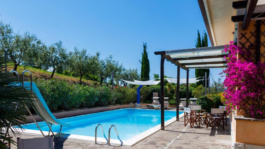 - une piscine avec une chaise et un kiosque dans l'établissement Villa delle Rose - Modern design, pool & AirCO, à Colbordolo