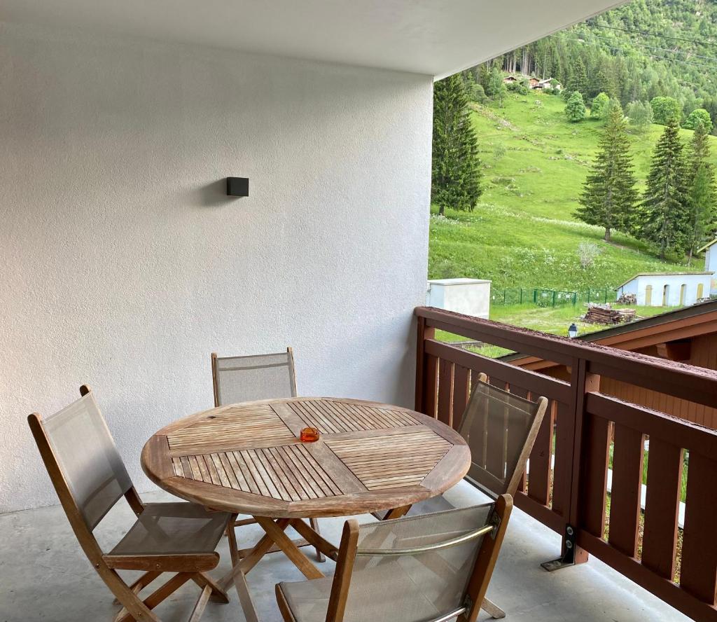 d'une table et de chaises en bois sur un balcon avec vue. dans l'établissement Le REFUGE DES PORTES DU MONT BLANC, à Vallorcine