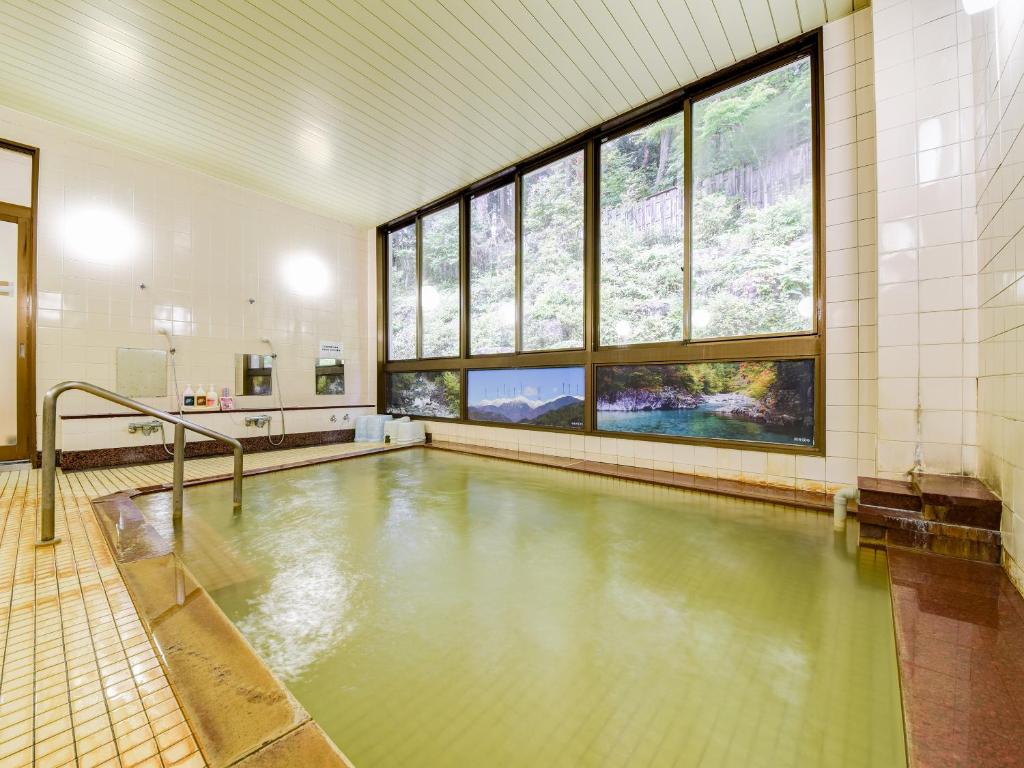 une piscine vide dans un immeuble avec des fenêtres dans l'établissement 阿寺温泉 フォレスパ木曽あてら荘, à Okuwa