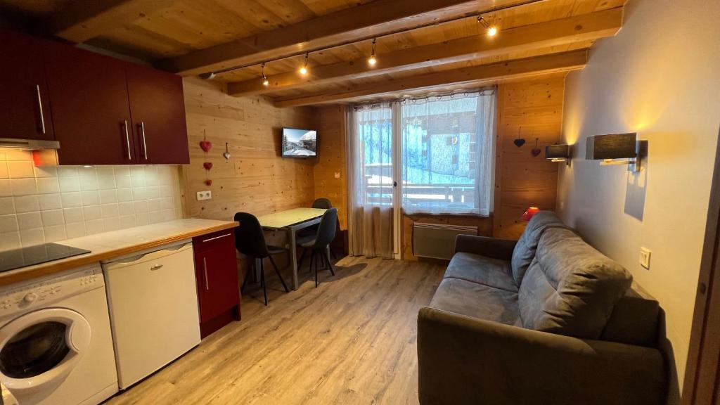 un salon avec un canapé et une cuisine dans l'établissement Parnasse 2-203 - Bel appartement sur les pistes de ski et dans le village, au calme, à La Clusaz